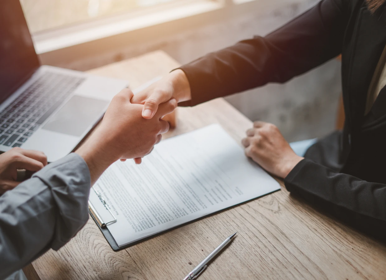 Handshake over a contract on desk